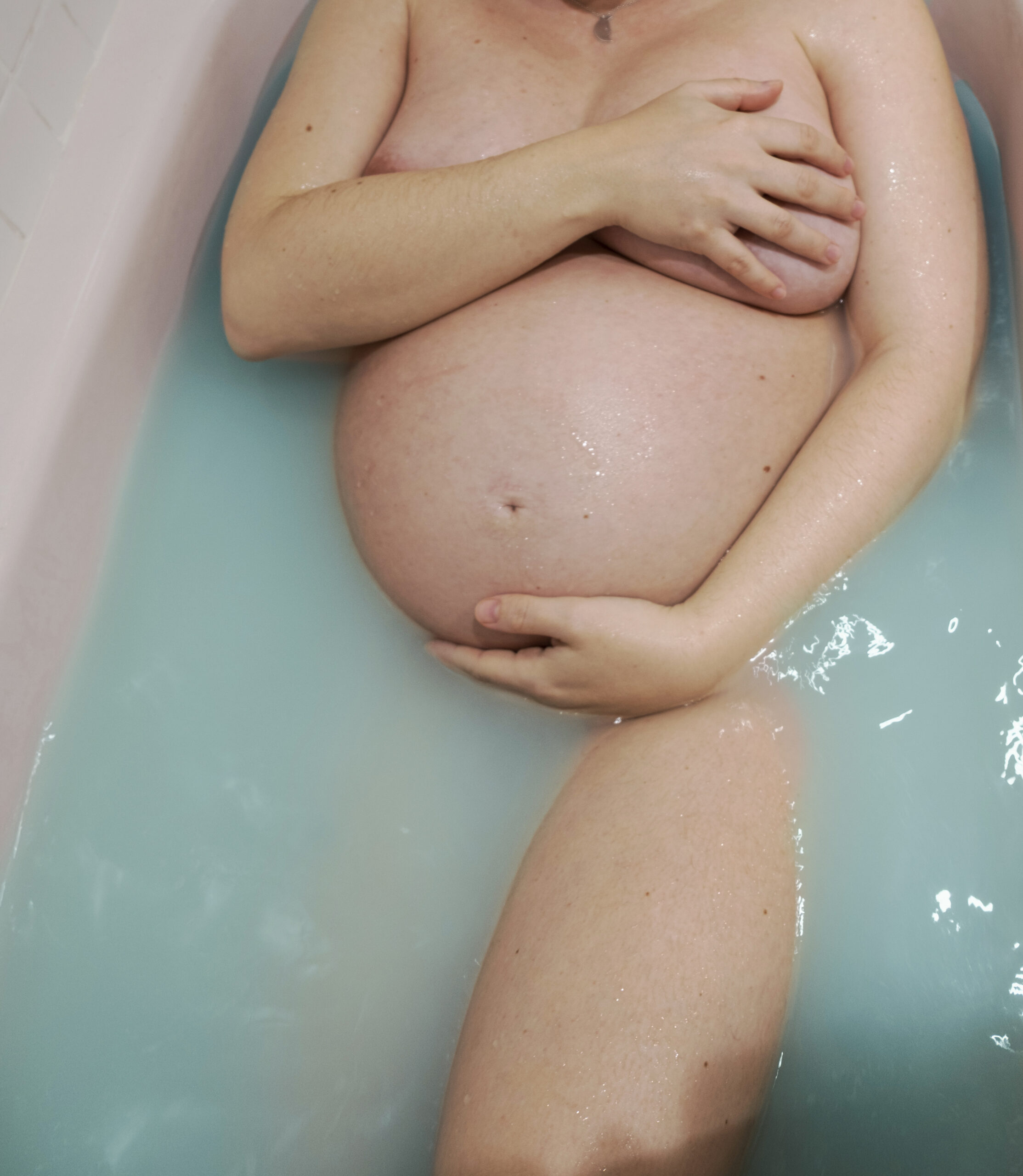 mujer embarazada caminando por la orilla de playa en barcelona