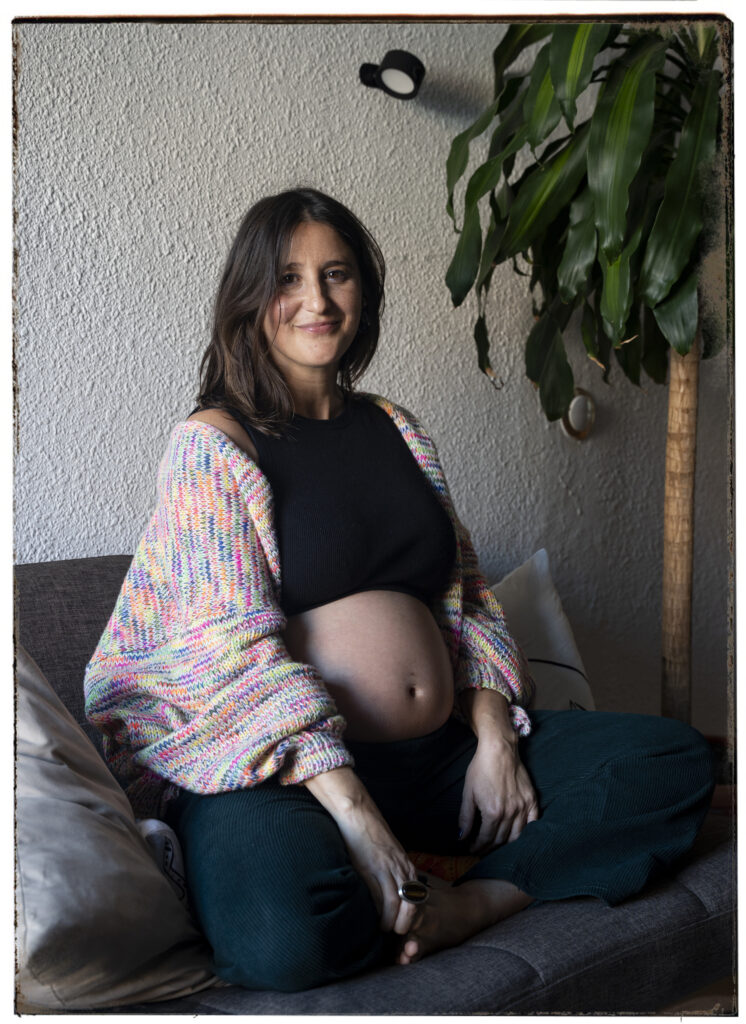 mujer embarazada sentada en sillón de casa en barcelona